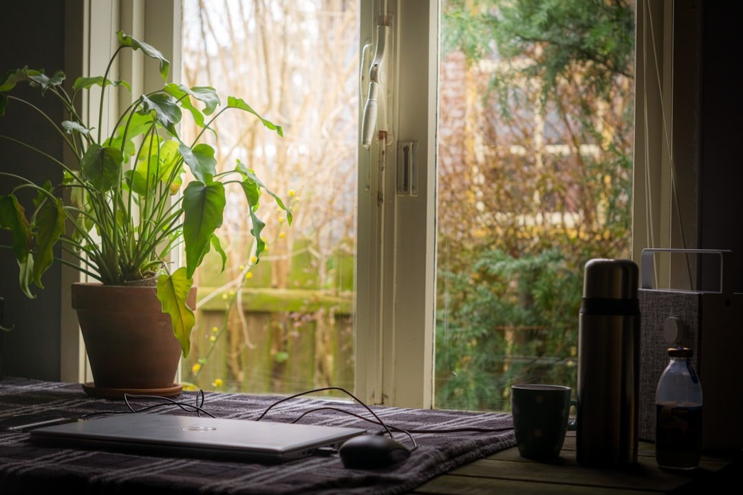 Desk with a laptop, notebook and coffee cup in a bright home office