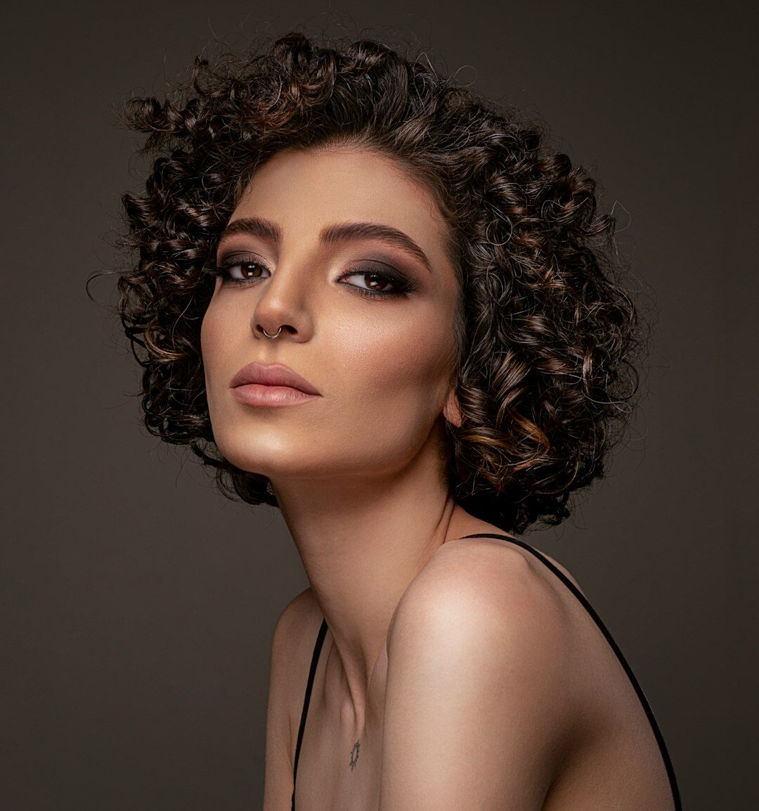 Studio portrait of a Portuguese woman with curly hair smiling
